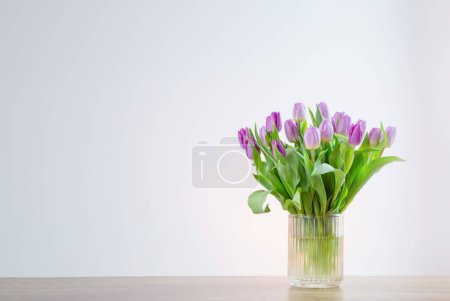 Téléchargez les photos : Tulipes roses dans un vase en verre sur fond blanc - en image libre de droit