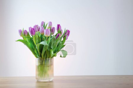Foto de Tulipanes rosados en jarrón de cristal sobre fondo blanco - Imagen libre de derechos