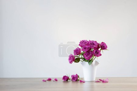 Foto de Rosas púrpuras en jarrón sobre fondo blanco - Imagen libre de derechos