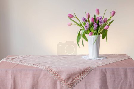 Téléchargez les photos : Fleurs de printemps en vase blanc dans un style vintage - en image libre de droit
