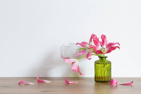 Foto de Tulipanes rosados en jarrón de cristal verde sobre fondo blanco - Imagen libre de derechos