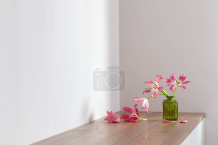Téléchargez les photos : Tulipes roses en verre vase vert sur fond blanc - en image libre de droit