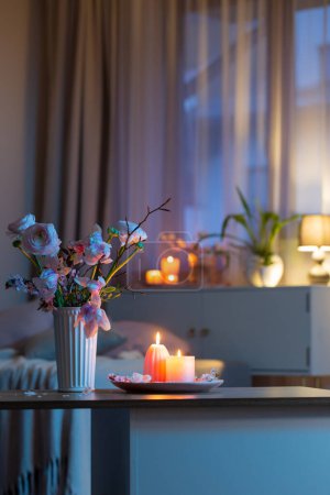 Téléchargez les photos : Intérieur de la maison avec des fleurs de printemps et des bougies allumées - en image libre de droit