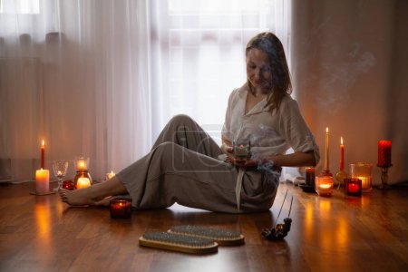 Foto de Mujer joven interior con tablero de uñas y velas encendidas - Imagen libre de derechos