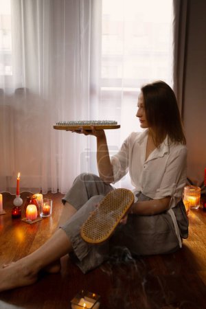 Téléchargez les photos : Jeune femme intérieure avec planche à ongles et bougies allumées - en image libre de droit
