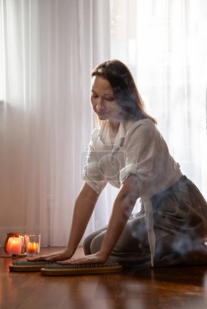 Photo for Young woman indoor with nail board and burning candles - Royalty Free Image