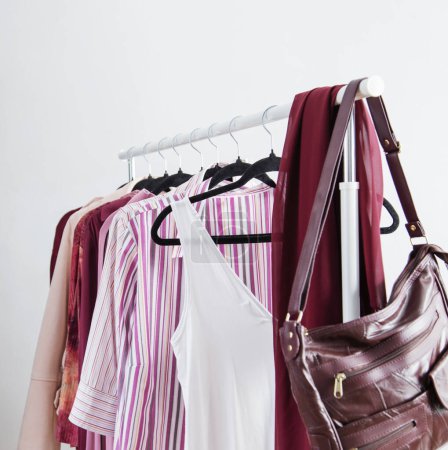 vêtements pour femmes en rose et bordeaux couleurs tendance sur un cintre