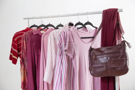 Téléchargez les photos : Vêtements pour femmes en rose et bordeaux couleurs tendance sur un cintre - en image libre de droit