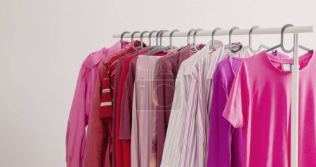 ropa de mujer en colores de moda rosa y burdeos en una percha