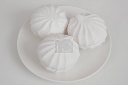 Téléchargez les photos : Zéphyr blanc ou guimauve sur plaque de porcelaine. Gâteau doux Airy et tendre. - en image libre de droit