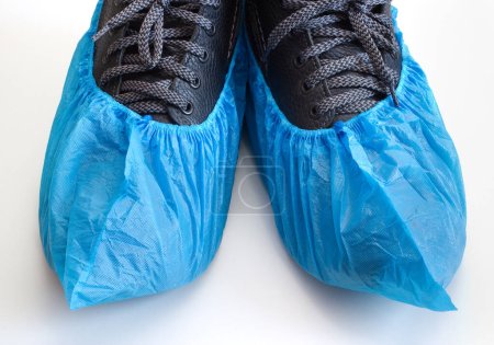 Des chaussures sur les bottes. Couverture médicale bleue pour la visite à l'hôpital.