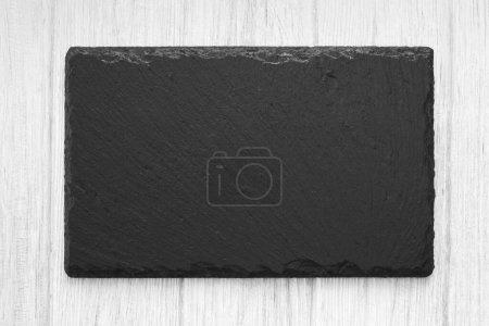 Photo for White wooden table background with natural slate stone empty board. Decorative black plate for food serving. - Royalty Free Image
