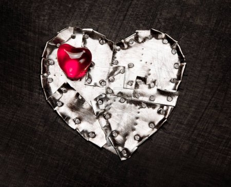 Foto de Corazón blindado de metal y corazón de cristal rojo en él
. - Imagen libre de derechos