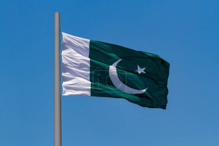 Photo for Flag of Pakistan waving in the wind on a pole against blue sky - Royalty Free Image
