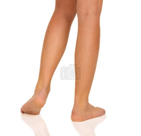 Foto de Las piernas de una mujer joven sobre un fondo blanco, primer plano, aislado - Imagen libre de derechos