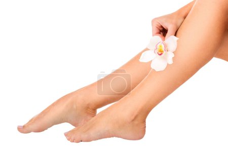 Téléchargez les photos : Belles jambes féminines avec fleur d'orchidée, isolé, gros plan - en image libre de droit