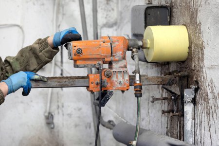 Foto de Trabajador usando un taladro eléctrico para hacer un agujero en una pared de hormigón, primer plano - Imagen libre de derechos