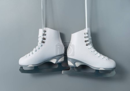 Foto de Pair of white figure ice skates shoes on blank gray background - Imagen libre de derechos