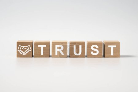 Wooden blocks with the word Trust isolated for trust relationships between business partners, friends, relatives, respect and authority or confidence in a person.