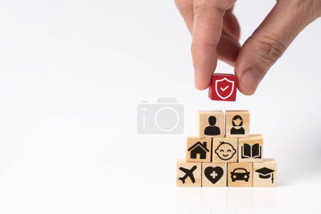 Téléchargez les photos : Main mettant un bouclier rouge protection bloc de bois sur les soins de santé médicale, vie, voiture, maison, Voyage, icônes de l'éducation pour l'important de service d'assurance - en image libre de droit