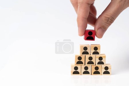 Téléchargez les photos : Placer à la main un bloc de cube en bois rouge représente un chef de groupe sur la pyramide des blocs de cube en bois, concept de processus de recrutement de la gestion des ressources humaines à la recherche de talents, de gestionnaires ou de leaders - en image libre de droit