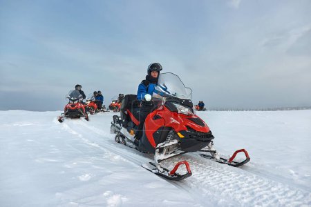 Montar en una moto de nieve en Finlandia, jinete femenino sobre el Círculo Polar Ártico