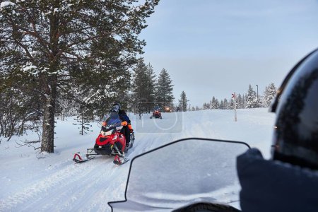 Téléchargez les photos : Riding on a snowmobile in Finland, traffic near a Lapland village - en image libre de droit