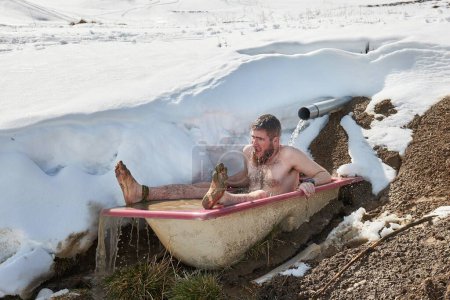 Cold plunge, outdoor cold water inmersion in an old bathtub left by a mountain spring in the ALps