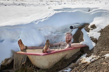 Plongée froide hivernale, immersion extérieure en eau froide dans une vieille baignoire laissée par une source montagneuse dans les Alpes