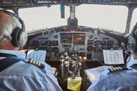 Foto de Auckland, Nueva Zelanda - 06 de marzo de 2016: Pilotos experimentados volando un viejo avión DC-3 con cabina abierta, Air Chathams - Imagen libre de derechos