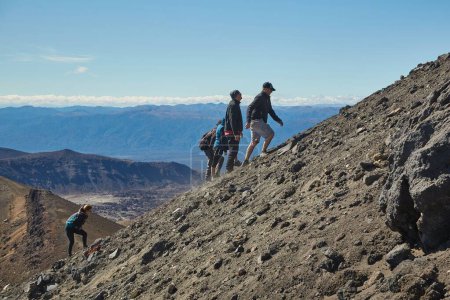 Téléchargez les photos : Tongariro Alpine Crossing, Nouvelle-Zélande - Le 02 avril 2016 : Un touriste monte la pente abrupte du mont Ngauruhoe, célèbre volcan uset sous le nom de mont Doom dans les films du Seigneur des Anneaux - en image libre de droit