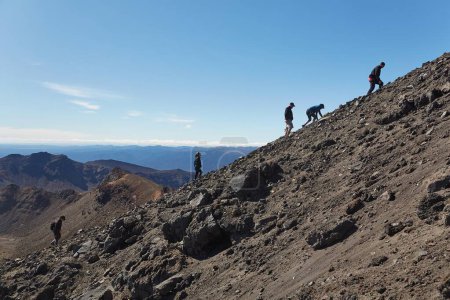 Photo for Tongariro Alpine Crossing, New Zealand - April 02, 2016: Tourist ascending the steep rough slope of mount Ngauruhoe, famous volcano uset as Mount Doom in the Lord of The Rings movies - Royalty Free Image