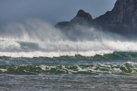 Téléchargez les photos : Fortes vagues dans le vent orageux, frappant des falaises sur le rivage de la Nouvelle-Zélande - en image libre de droit