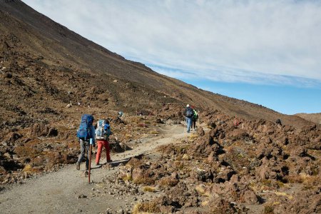 Photo for Mountain hiking trail landscape in New Zealand. Unrecognizable hikers on the Tongariro Alpine Crossing great walk, National Park, volcanic scenery - Royalty Free Image