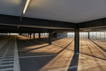 Téléchargez les photos : Parking vide avec rayons de soleil et ombres - en image libre de droit