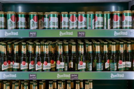 Foto de Plzen, República Checa - 6 de junio de 2022: Latas de cerveza Pilsner Urquell en un estante en la tienda de regalos de la cervecería Pilsner - Imagen libre de derechos