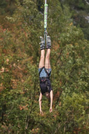 Photo for Bungee jumping girl hanging on the rope screaming in excitement - Royalty Free Image