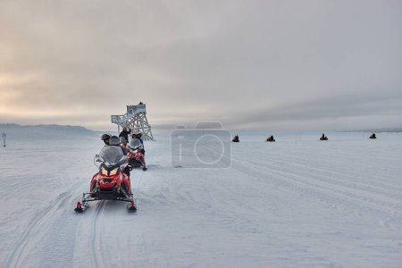 Téléchargez les photos : Saarilselka, Finlande - 20 février 2022 : Monter en motoneige en Finlande, aventure de groupe au-dessus du cercle polaire arctique. Toundra de Laponie paysage - en image libre de droit