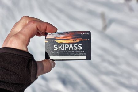 Foto de Alpe dHuez, Francia - 26 de enero de 2022: Pase de esquí cogido de la mano por el esquiador en un paisaje nevado de montaña Oz Vaujany, parte de la estación de esquí Alpe dHuez - Imagen libre de derechos