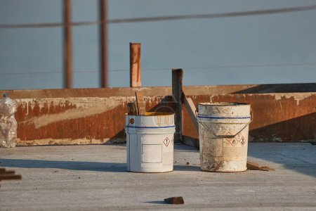Photo for Buckets and tools at a construction site on a building roof being reconstructed - Royalty Free Image