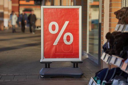 Photo for Large discount sign board on a shopping street showing just a percent sing in front of a shop entrance - Royalty Free Image