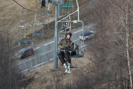 Photo for Ski lift in the Alps with lack of snow after heavy melting, complete lack of snow in the lower section of the ski resort Les 2 Alpes. Man in skis laughing about the hopelessness of the situation - Royalty Free Image