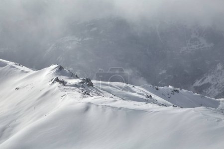 Photo for Winter high mountain landscape covered in clouds and snow, jagged rock ridge formations - Royalty Free Image