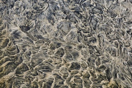 Photo for Sand flow patterns on a beach with shallow waters shaping abstract structures at low tide - Royalty Free Image