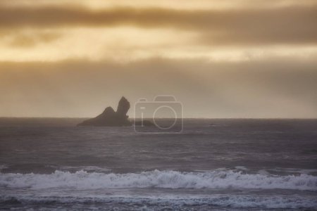 Photo for Sea landscape with haze, rocky cliff island in the mist - Royalty Free Image