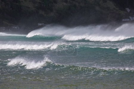 Starke Wellen im Wind, die mit großer Wucht auf die Küste treffen