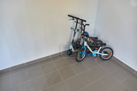Kinderfahrräder und Motorroller in der Garagenecke abgestellt