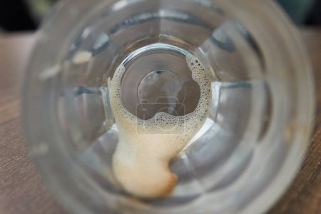 Blick in eine leere Kaffeetasse mit nur übrig gebliebenen Tropfen im Glas