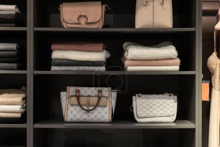 Clothes bags and accessories displayed neatly in a wardrobe closet or shop shelf