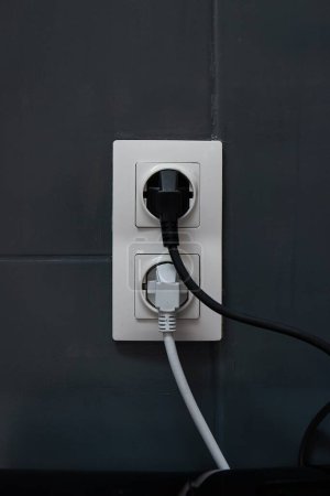Electric wall outlets with cable connected, pluged into sockets above kitchen counter, European Type F socket and plug